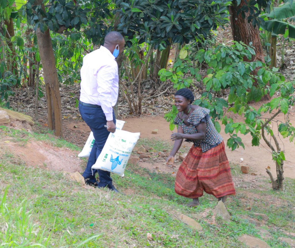 Nabwami Olivia (widow 27 years) happily running to receive Covid 19 relief aid from a PaCT worker after spending 3 months with hardly anything to feed her family of five orphans and her own mother.
